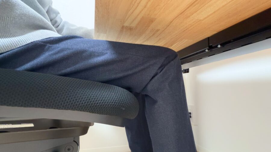 FlexiSpot E7 Proのコ型フレーム構造で、椅子を深く引いても膝が脚フレームに干渉しない足元の様子